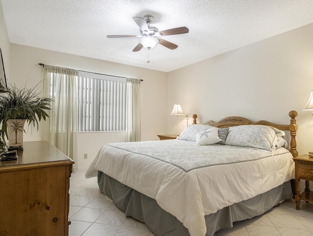 tiled bedroom featuring ceiling fan and a textured ceiling