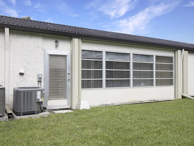 rear view of house featuring a yard and cooling unit