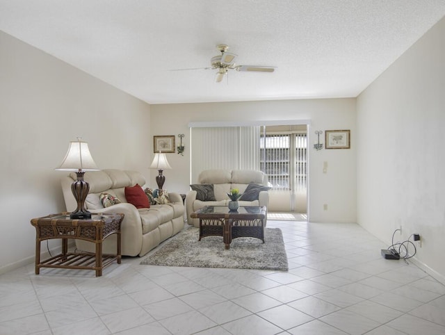 living room featuring ceiling fan, light tile patterned flooring, and a textured ceiling