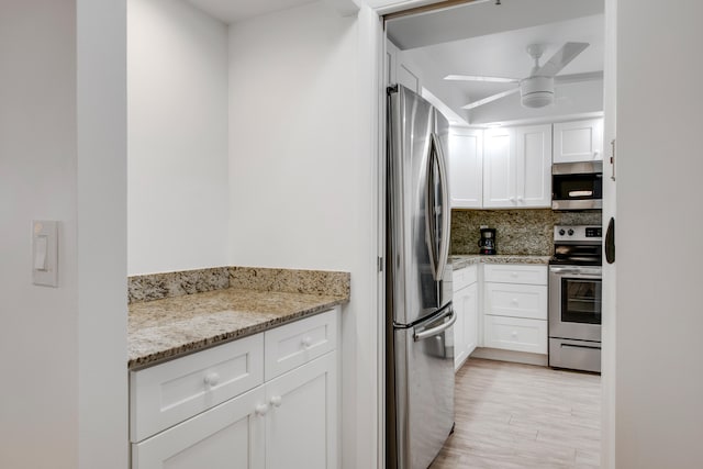 kitchen featuring appliances with stainless steel finishes, white cabinetry, tasteful backsplash, and ceiling fan