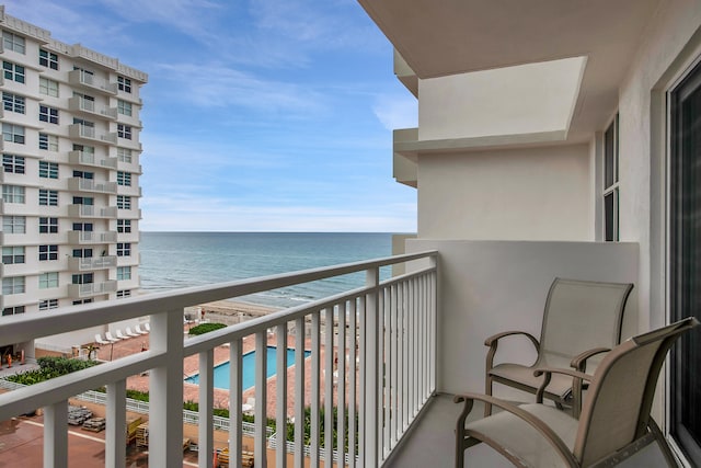 balcony with a community pool and a water view