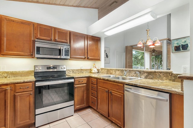 kitchen with stainless steel appliances, light tile patterned floors, a notable chandelier, light stone counters, and sink