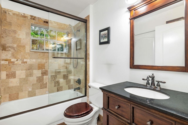 full bathroom featuring toilet, vanity, and enclosed tub / shower combo