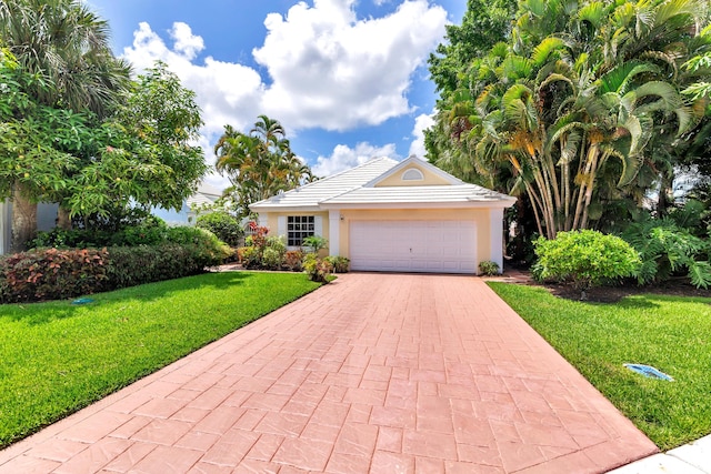 view of front of home with a front yard and a garage