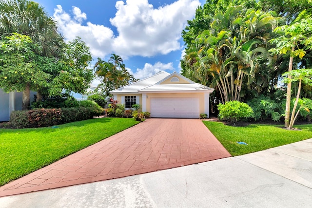 view of front of property with a front yard and a garage