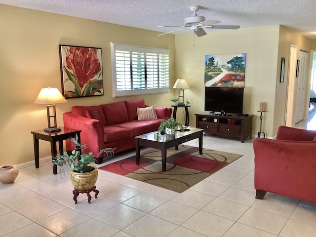 living room with ceiling fan, light tile patterned floors, and a textured ceiling