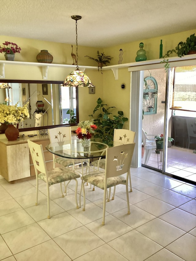 dining space with light tile patterned flooring and a textured ceiling