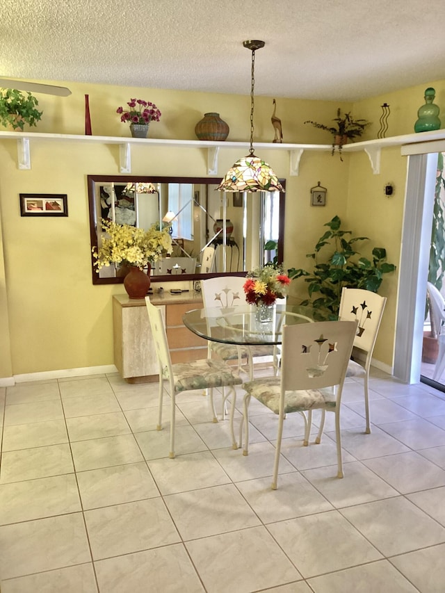 dining room featuring tile patterned floors and a textured ceiling