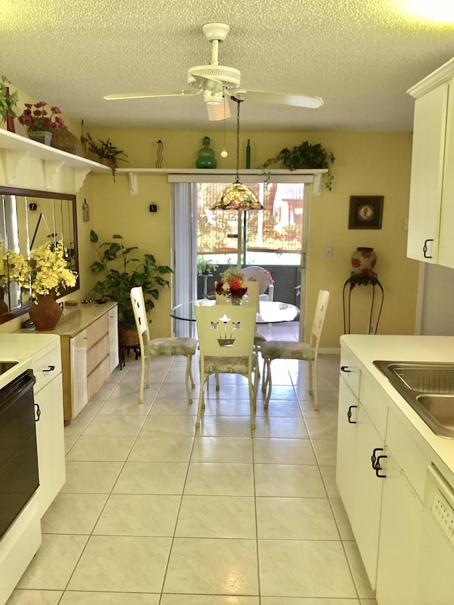 dining room featuring ceiling fan, light tile patterned flooring, and a textured ceiling