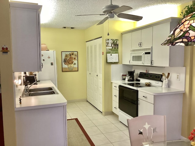 kitchen featuring white appliances, a textured ceiling, ceiling fan, sink, and light tile patterned floors