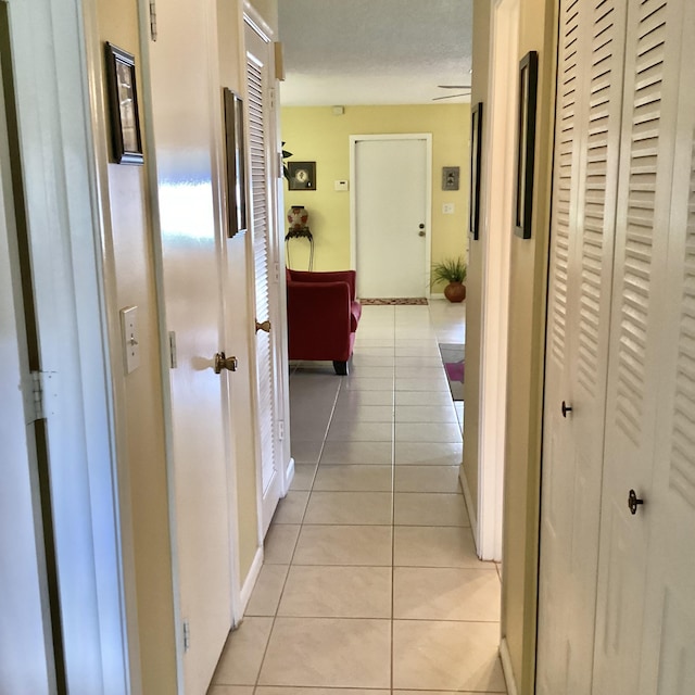 corridor featuring light tile patterned floors and a textured ceiling