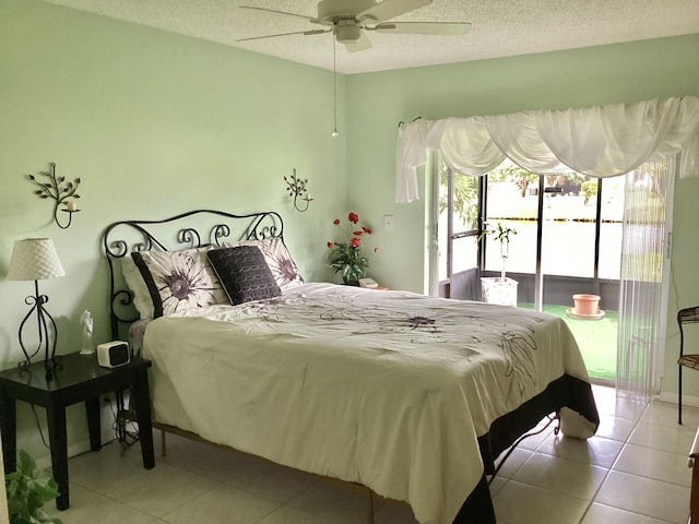 bedroom with a textured ceiling, ceiling fan, and light tile patterned flooring