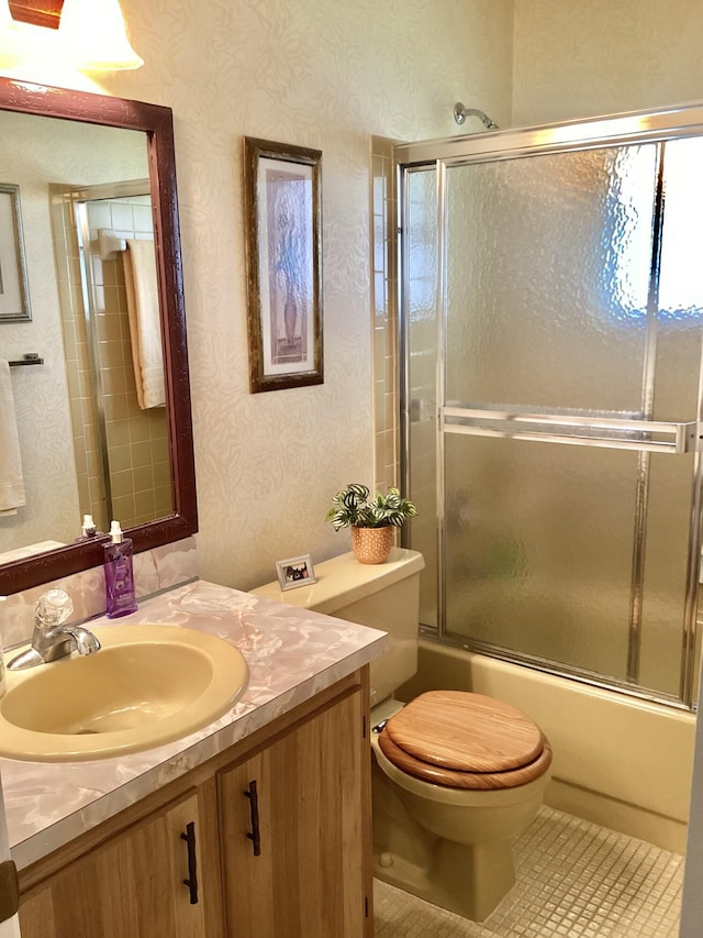 full bathroom with tile patterned floors, vanity, toilet, and enclosed tub / shower combo