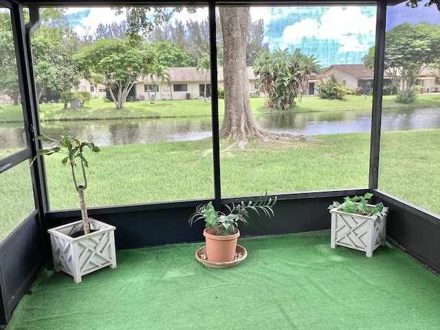 sunroom featuring a water view