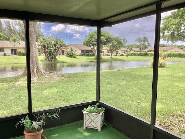 unfurnished sunroom featuring a water view