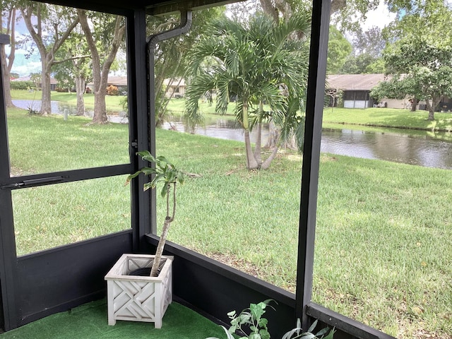 unfurnished sunroom featuring a water view