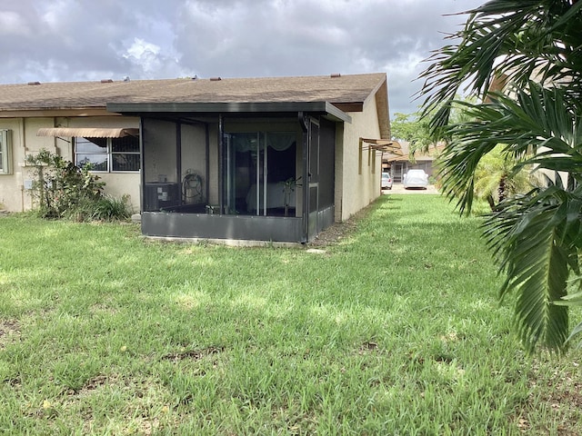 back of property featuring a yard and a sunroom