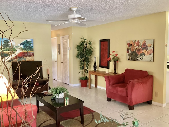 interior space with ceiling fan, light tile patterned floors, and a textured ceiling