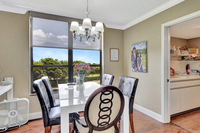 dining room with an inviting chandelier, crown molding, and light hardwood / wood-style floors