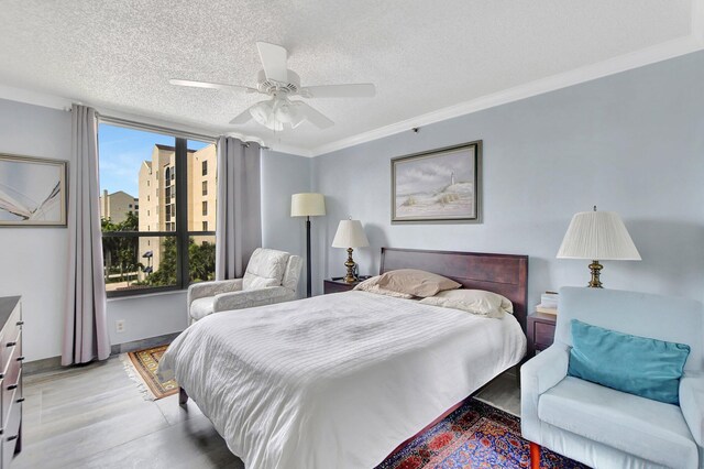 bedroom with a textured ceiling, crown molding, light hardwood / wood-style flooring, and ceiling fan