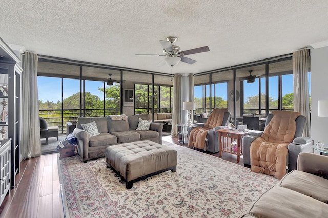 living room featuring a textured ceiling, expansive windows, wood-type flooring, and ceiling fan