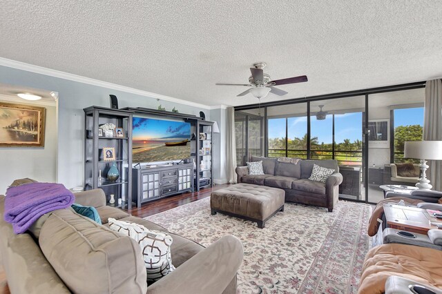 living room with ceiling fan, a textured ceiling, hardwood / wood-style flooring, and crown molding