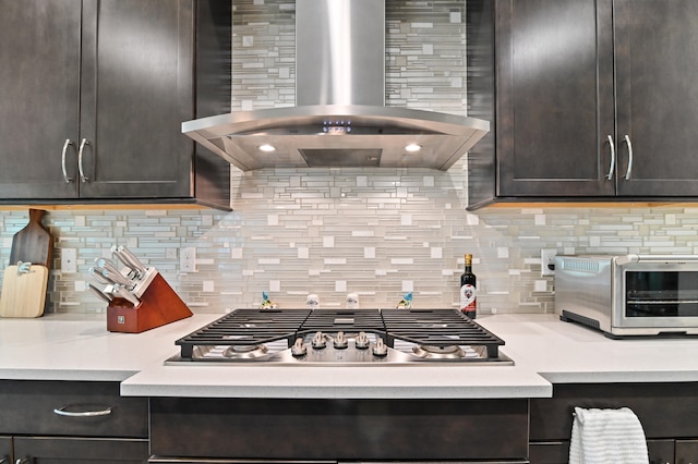 kitchen with dark brown cabinetry, ventilation hood, and decorative backsplash