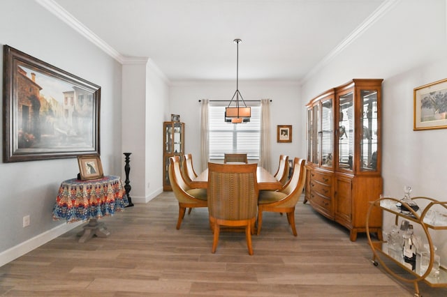 dining room featuring crown molding and light wood-type flooring