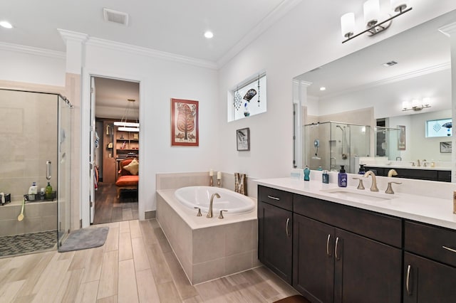 bathroom featuring crown molding, vanity, and independent shower and bath