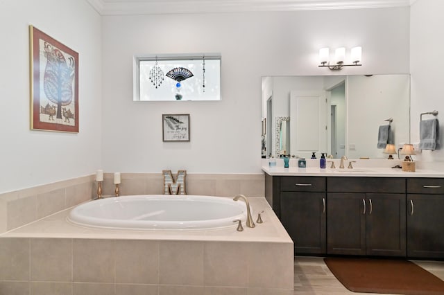 bathroom with ornamental molding, vanity, and tiled bath