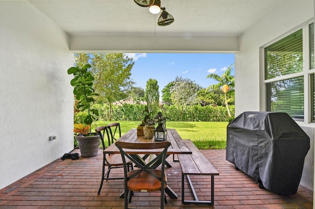 deck with a grill, ceiling fan, and a lawn