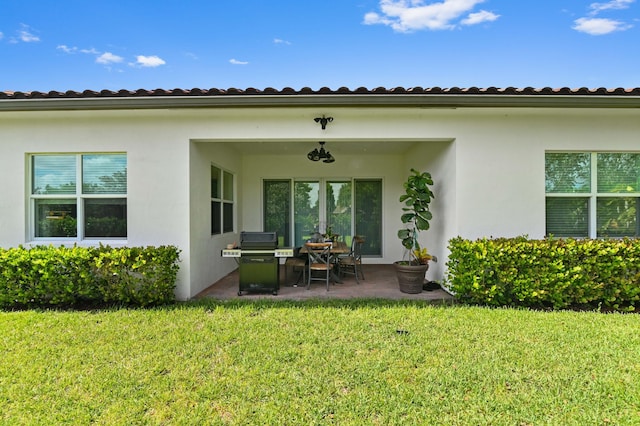 back of house with a yard and a patio area