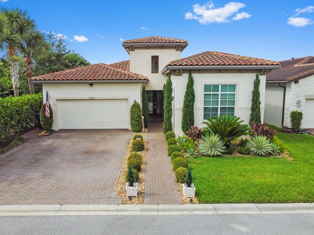 mediterranean / spanish-style house with a garage and a front lawn