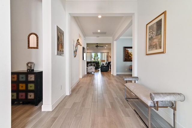 hallway featuring ornamental molding and light wood-type flooring