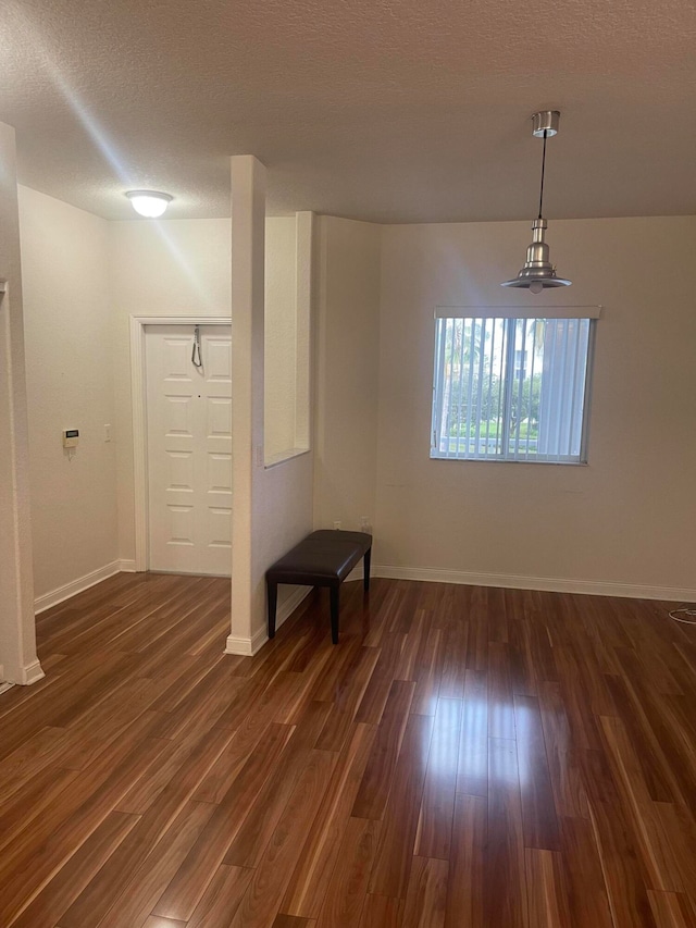 unfurnished room with dark hardwood / wood-style floors and a textured ceiling