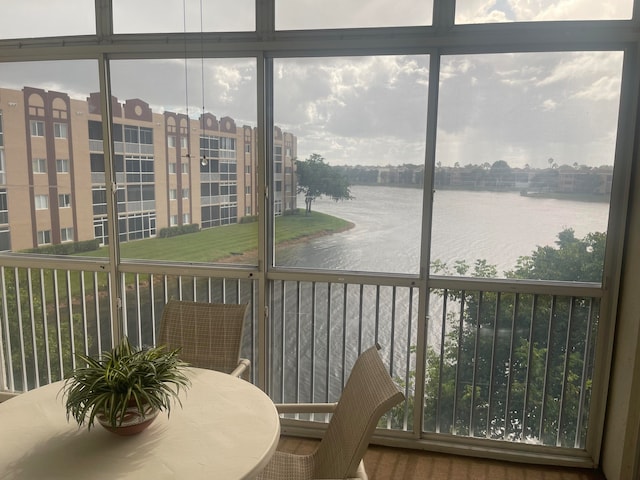 sunroom featuring a water view and a wealth of natural light