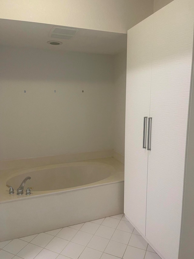 bathroom with tile patterned floors and a bath