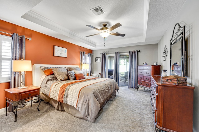 carpeted bedroom with a textured ceiling, ceiling fan, a raised ceiling, and access to outside