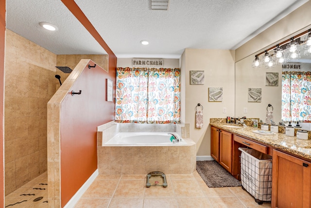 bathroom featuring shower with separate bathtub, oversized vanity, tile floors, and a textured ceiling