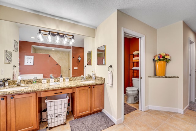 bathroom featuring tile floors, a textured ceiling, double sink vanity, and toilet