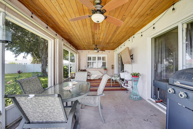 sunroom with ceiling fan and wooden ceiling