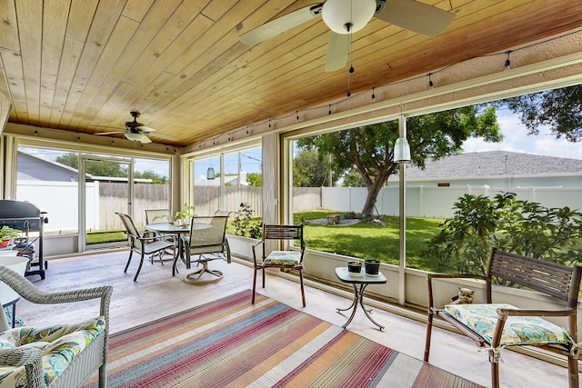 sunroom featuring ceiling fan and wood ceiling