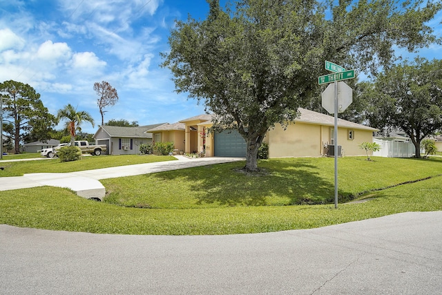 single story home featuring a garage, a front lawn, and central AC unit