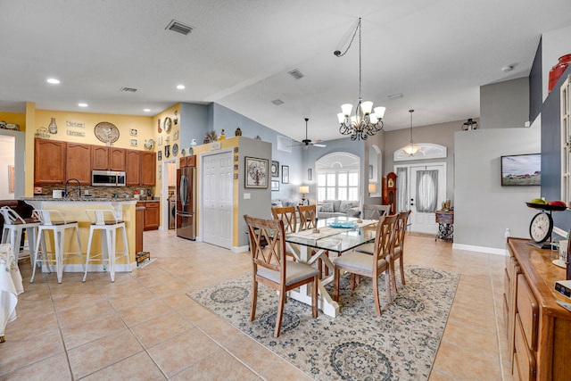 tiled dining space with vaulted ceiling and ceiling fan with notable chandelier