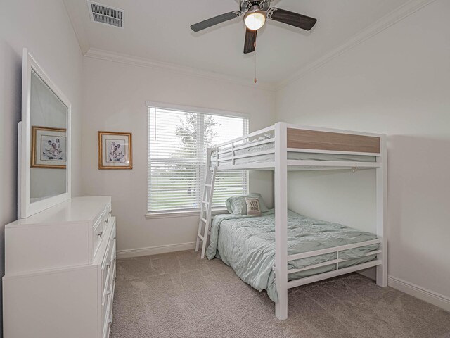 carpeted bedroom with ceiling fan and crown molding