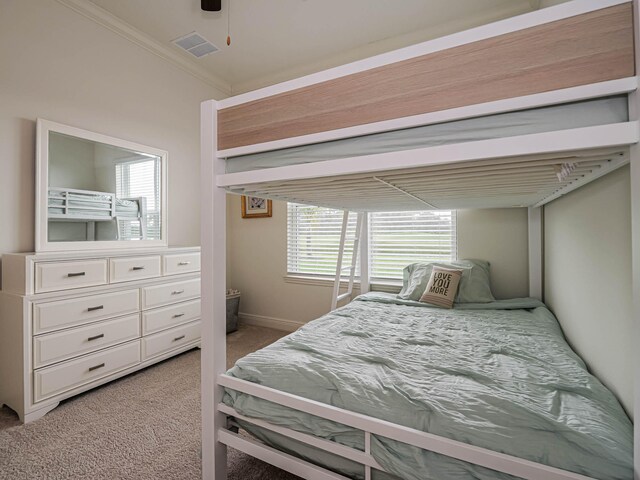 bedroom featuring ceiling fan, light colored carpet, and crown molding