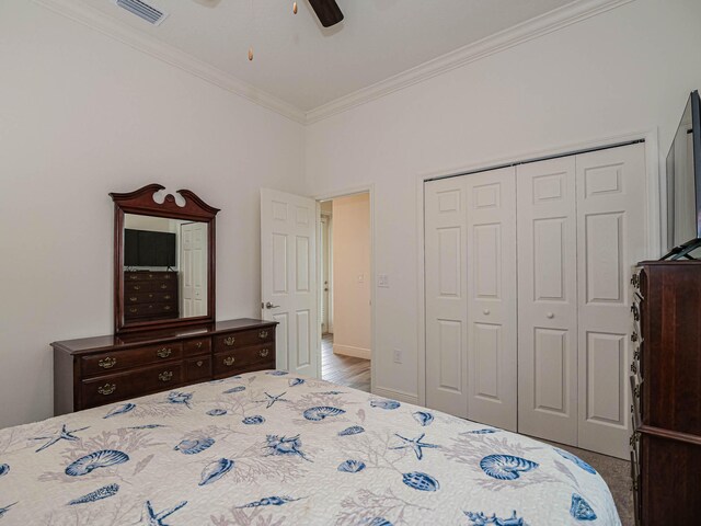 bedroom with ceiling fan, ornamental molding, and a closet