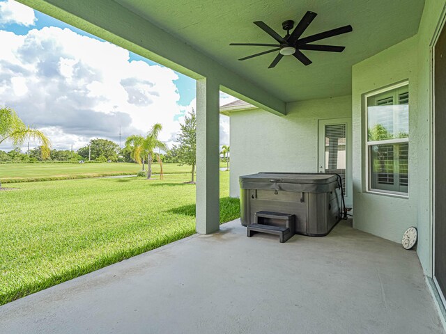 view of patio / terrace with ceiling fan and a hot tub