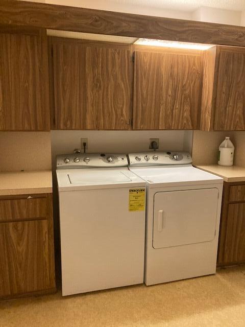 washroom featuring washing machine and dryer and cabinets