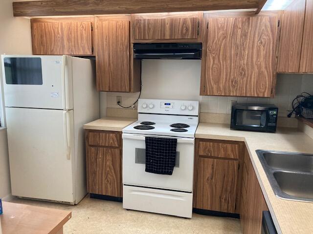 kitchen with white appliances, sink, extractor fan, and tasteful backsplash